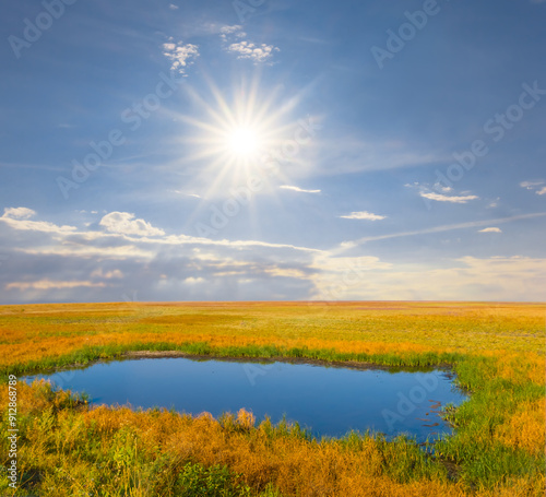 calm lake among prairie under a  sparkle cun photo