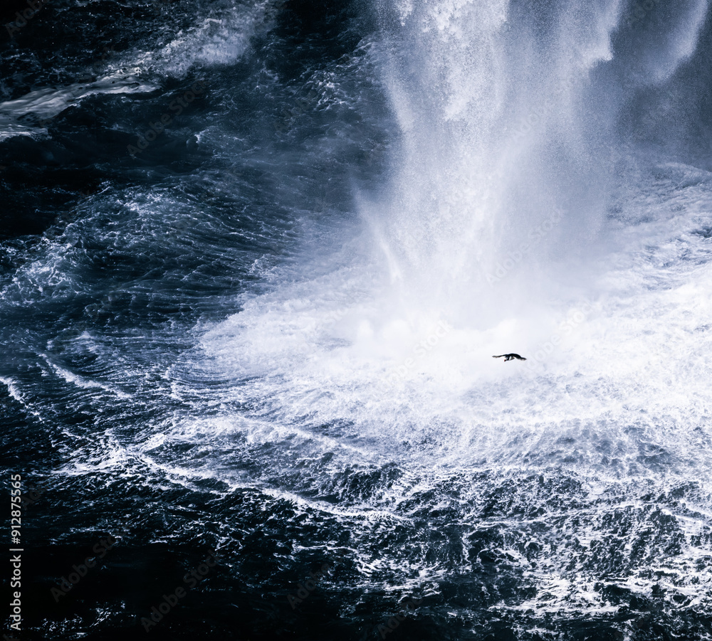 Fototapeta premium tiny puffin against large waterfall