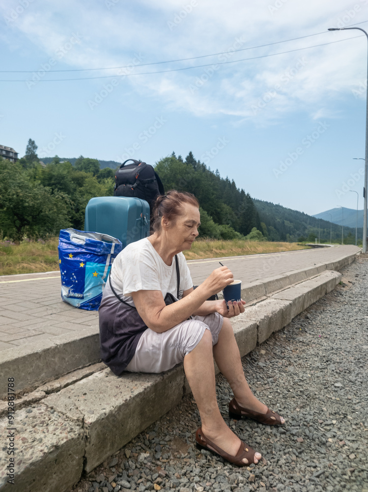 An elderly woman sits near the platform.