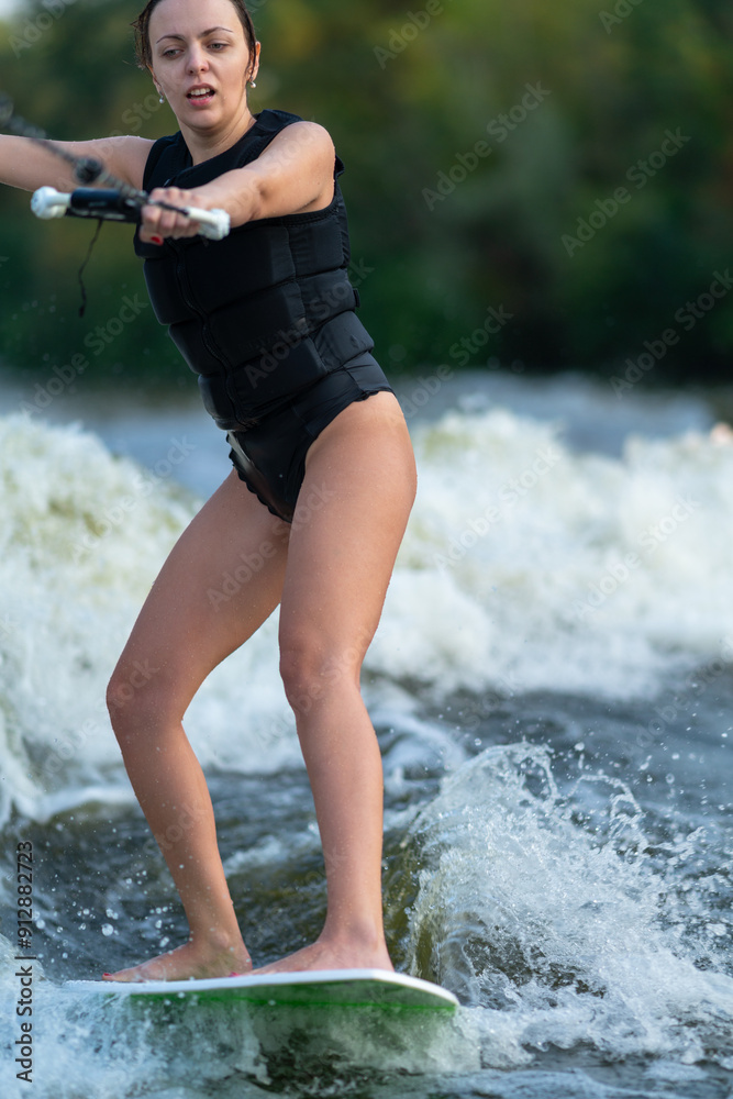A girl rides the waves on a wakeboard.