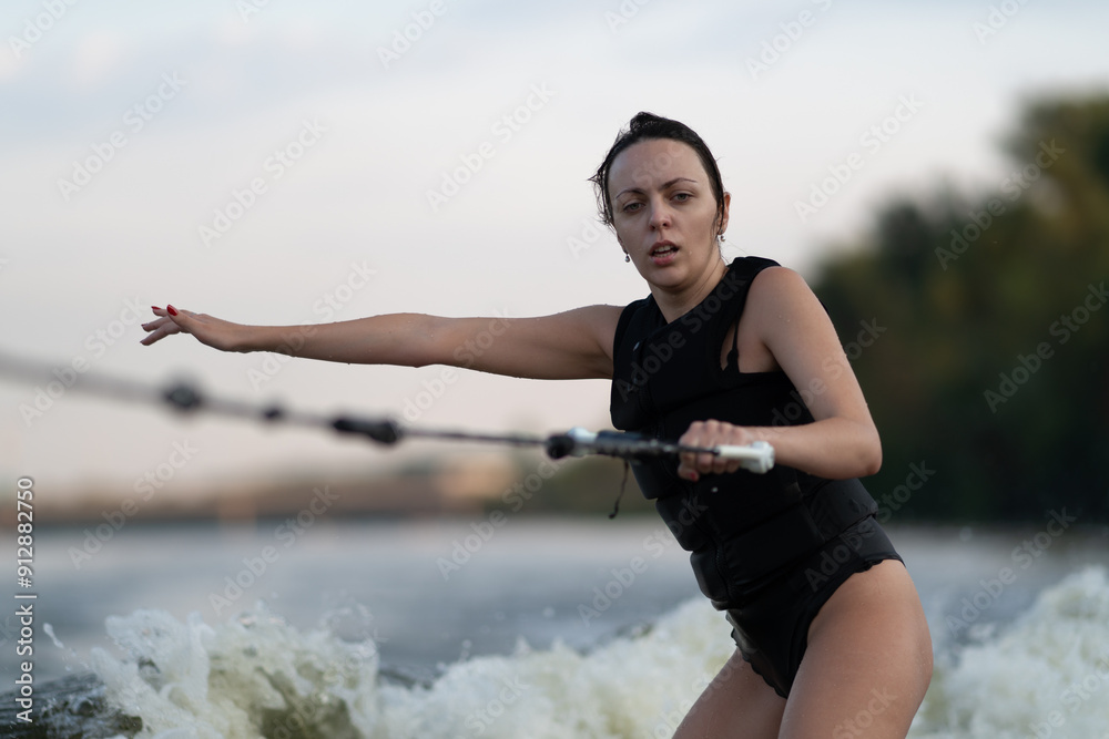 Surfing is being done by a girl on a river.