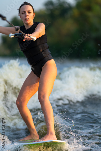 The waves are being ridden by a girl on a wakeboard.