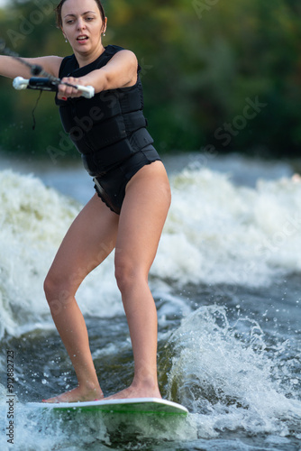Obraz na płótnie A girl rides the waves on a wakeboard. w salonie