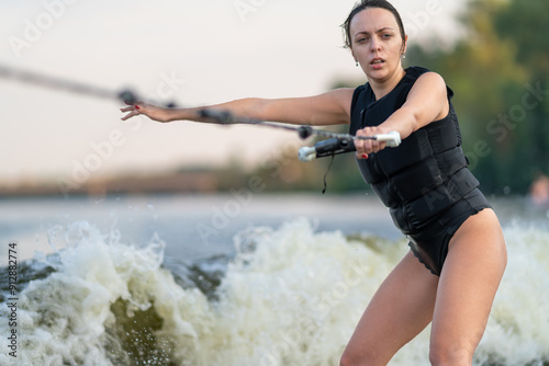 Obraz na płótnie Young female surfing holding on to a rope. w salonie