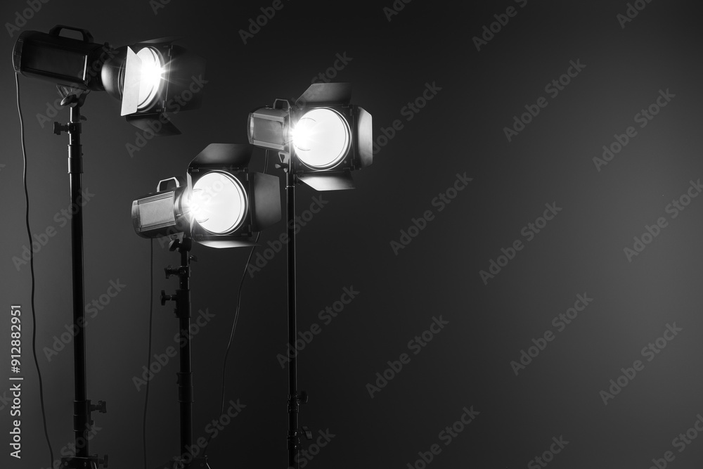 Dark photo background and professional lighting equipment in studio. Space for text Dark photo background and professional lighting equipment in studio. Space for text