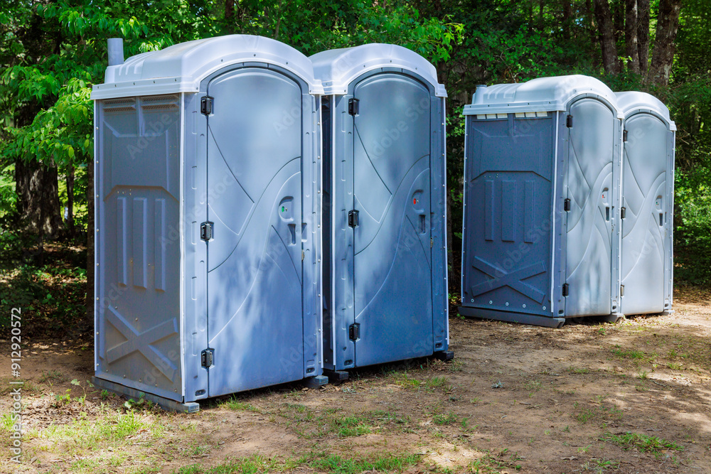 Long row portable bio of chemical toilets cabins in park center at city Long row portable bio of chemical toilets cabins in park center at city