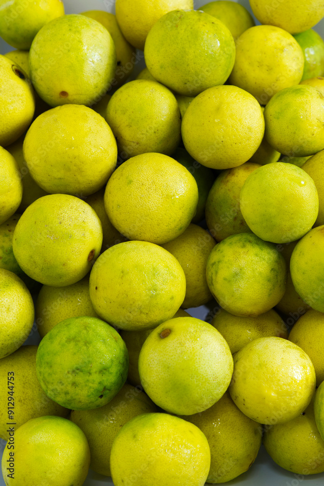 Yellow lime background. Close-up yellow lime texture with concepts of sour ingredients, Asian cuisine, organic, eating healthy, and cooking. Bright yellow food. Vertical texture background of limes. Yellow lime background. Close-up yellow lime texture with concepts of sour ingredients, Asian cuisine, organic, eating healthy, and cooking. Bright yellow food. Vertical texture background of limes.