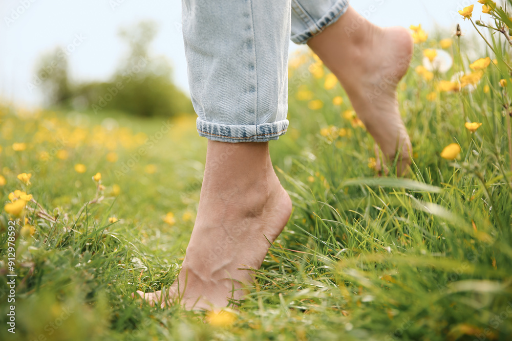 Woman walking barefoot on green grass outdoors, closeup Woman walking barefoot on green grass outdoors, closeup