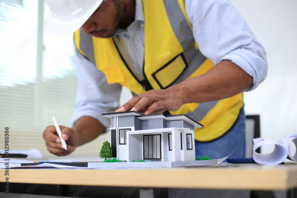 Asian architect and designer using blueprints and laptop to draw building structure in office. Construction concept, Engineering concept, Building plan, Building permit, Home architecture, Engineering