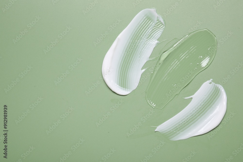 Face cream and gel on green background, top view. Space for text Face cream and gel on green background, top view. Space for text