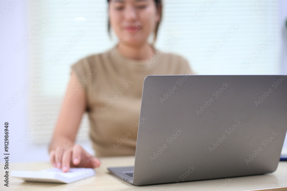 Successful Asian businesswoman sitting at desk working using laptop computer in office. Business and people concept. Businesswoman using laptop computer and working with documents. Successful Asian businesswoman sitting at desk working using laptop computer in office. Business and people concept. Businesswoman using laptop computer and working with documents.