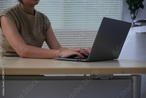 Successful Asian businesswoman sitting at desk working using laptop computer in office. Business and people concept. Businesswoman using laptop computer and working with documents.