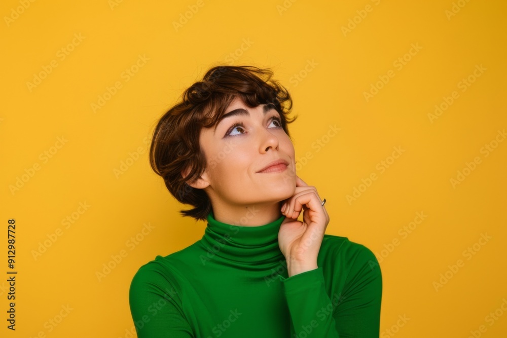 A woman with short hair is wearing a green sweater and looking up at the camera. She is deep in thought A woman with short hair is wearing a green sweater and looking up at the camera. She is deep in thought
