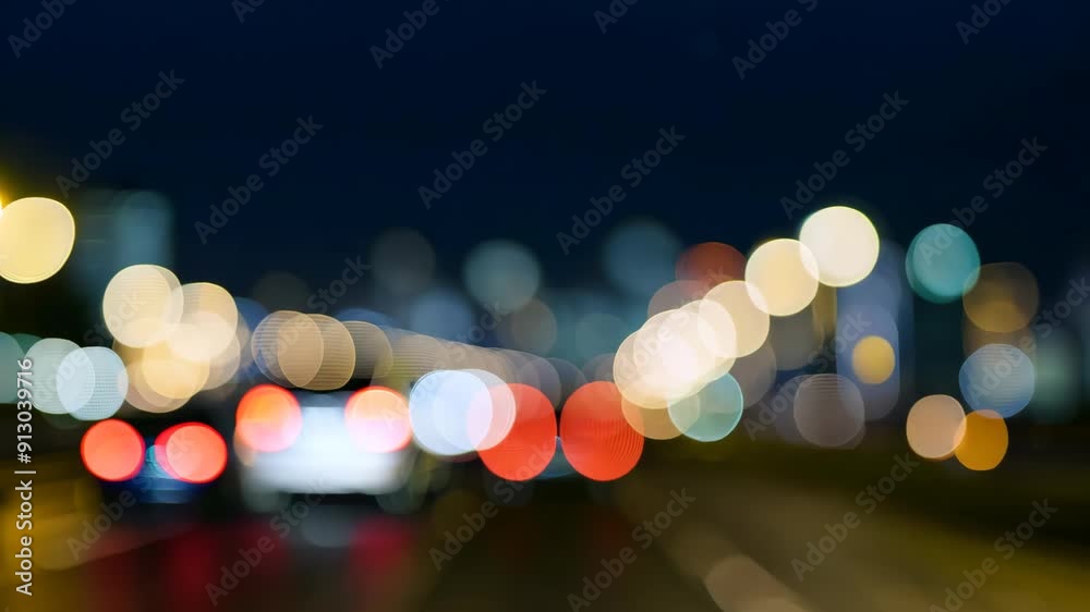City skyline bokeh with moving car lights and a blurred horizon at night.