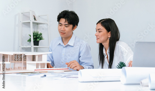 Portrait of cooperative engineer team working together to measure house model by using ruler and architectural equipment. Creative business design and teamwork concept. Immaculate..