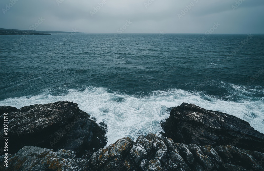 Fototapeta premium sea, with waves in shades of gray and green, seen from above on rocky cliffs