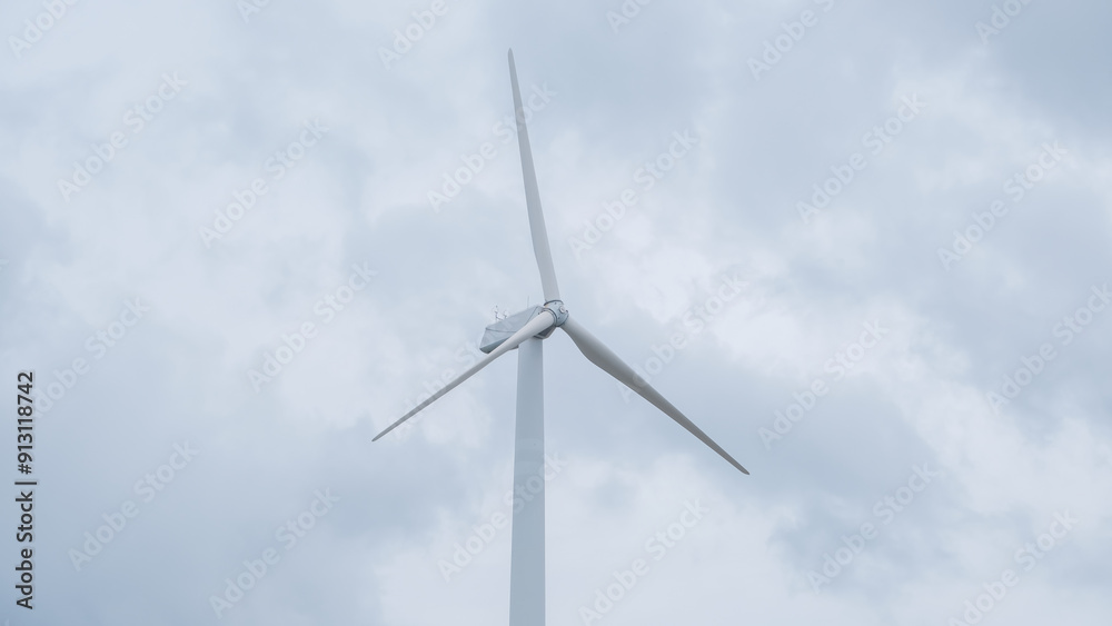 A large wind turbine under a cloudy sky, illustrating renewable energy and sustainable power generation. A large wind turbine under a cloudy sky, illustrating renewable energy and sustainable power generation.