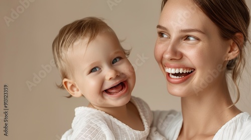 A joyful interaction between a mother and her delighted baby, captured in a light-filled studio.