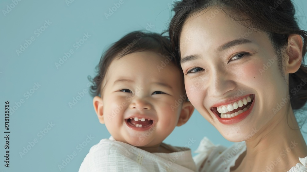 Emotional connection between an Asian mother and her joyful baby, captured in a light-filled studio. Emotional connection between an Asian mother and her joyful baby, captured in a light-filled studio.