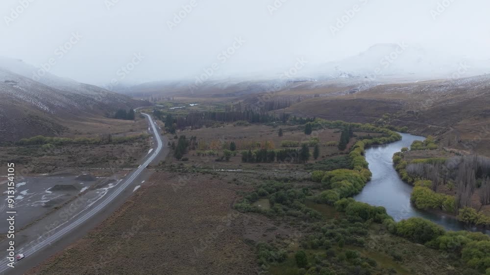 Aerial shot of a road next to a river in Patagonia Argentina, under winter weather conditions