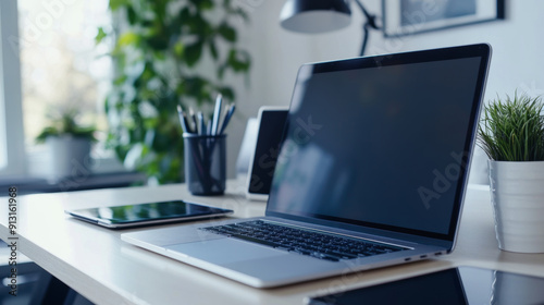 work-from-home setup, neat desk set up with laptop, tablet, and headphones for a productive remote work setup, promoting focus and efficiency while working from home