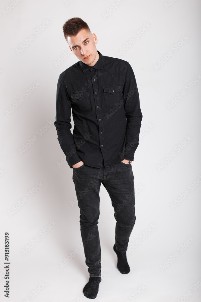 Handsome guy with fashion black clothes with shirt and jeans posing in studio on white background Handsome guy with fashion black clothes with shirt and jeans posing in studio on white background