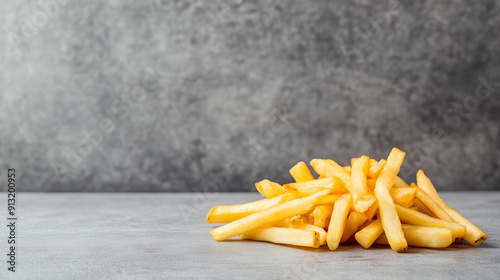 A photo of some fries in front of a grey background, showcasing their golden color and crispy texture.