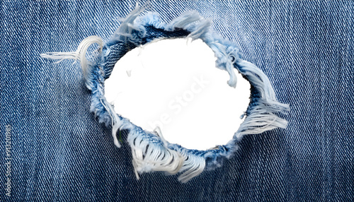  large hole in woen blue denim fabric isoleted photo