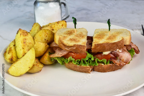 bacon , lettuce ,and tomato sandwich with potato wedges photo