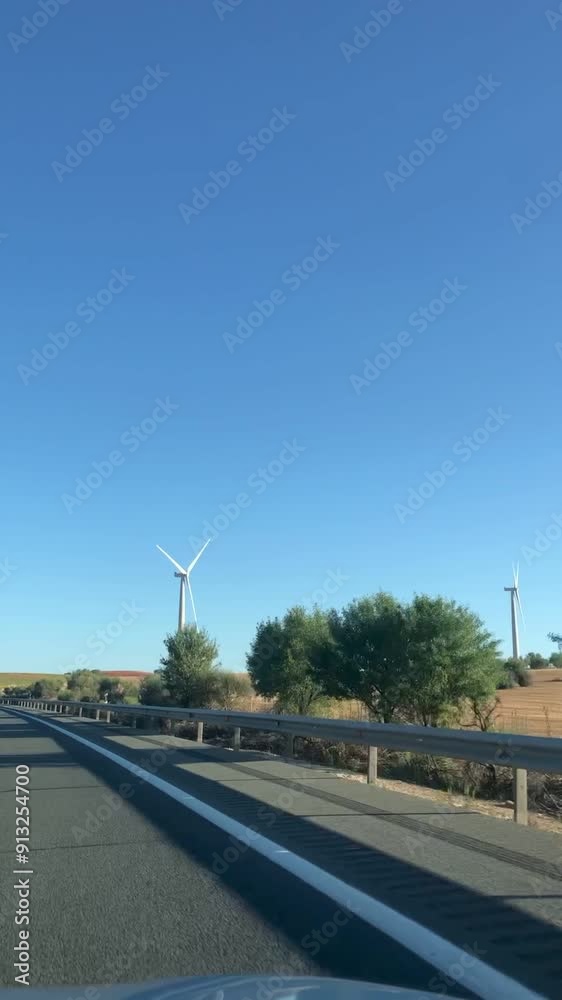 View to working windmills by road by car. Vertical orientation footage View to working windmills by road by car. Vertical orientation footage