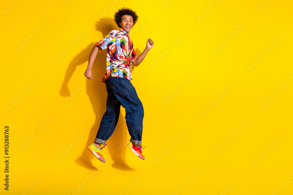 Full size photo of nice funky young man jump run wear shirt isolated on bright yellow color background Full size photo of nice funky young man jump run wear shirt isolated on bright yellow color background