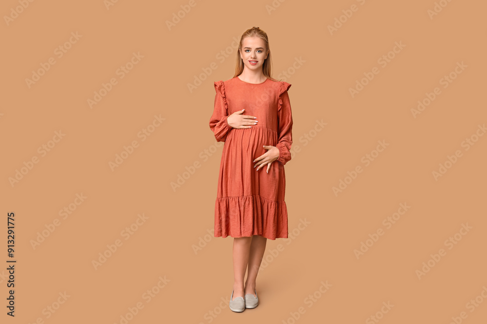 Beautiful happy pregnant woman on brown background