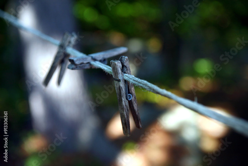 Close-up of old wooden clothespins on a clothesline with a bokha background.