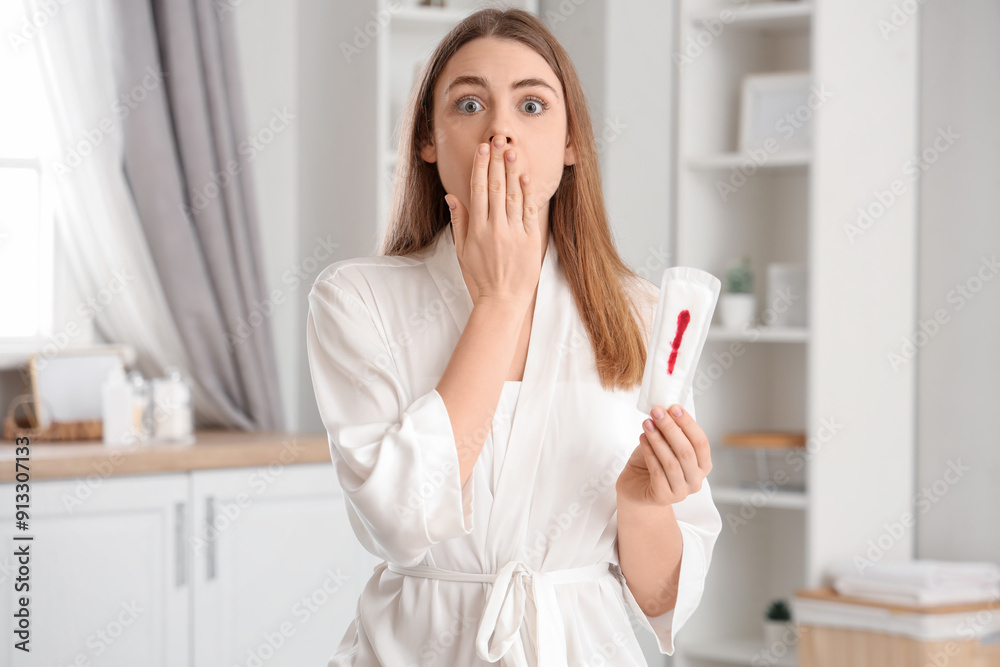Shocked young woman with dirty menstrual pad in bathroom Shocked young woman with dirty menstrual pad in bathroom