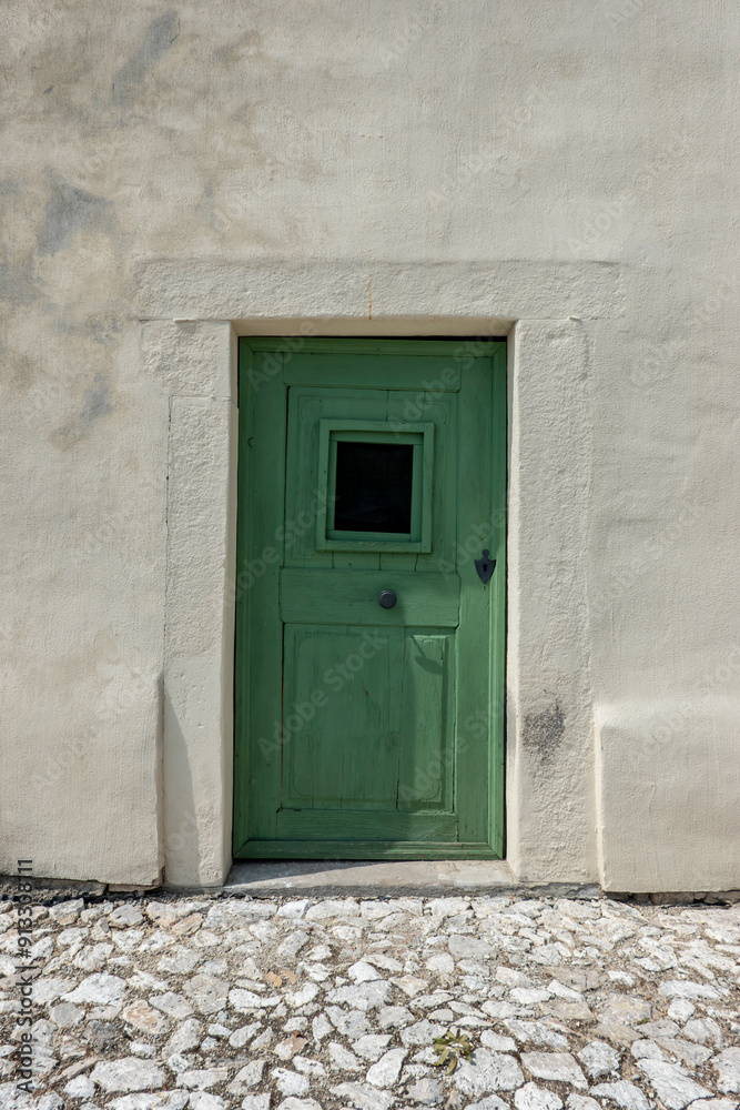 Old wooden green door on an ancient house Old wooden green door on an ancient house