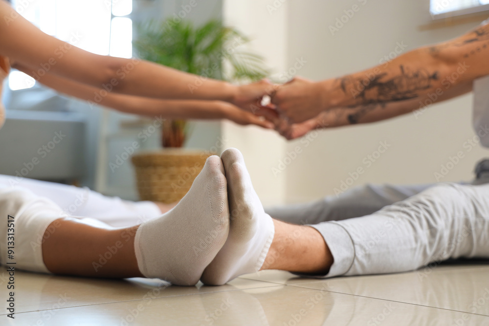 Young couple practicing yoga together at home, closeup Young couple practicing yoga together at home, closeup
