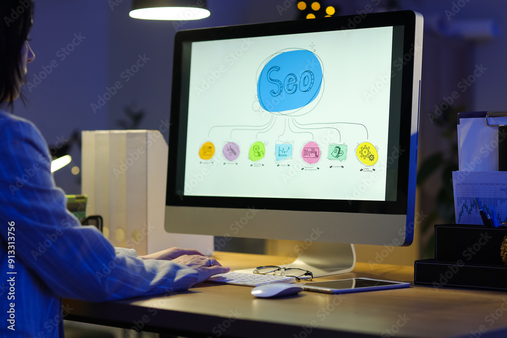Woman using computer with abbreviation SEO in dark office Woman using computer with abbreviation SEO in dark office