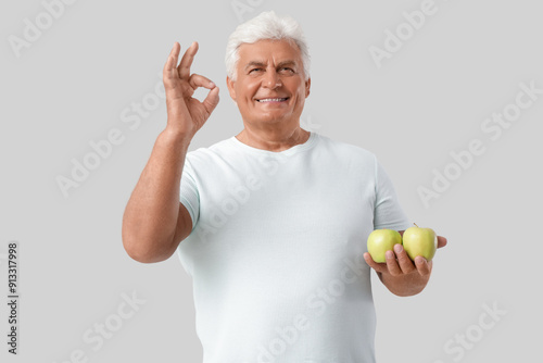 Mature man with apples show...