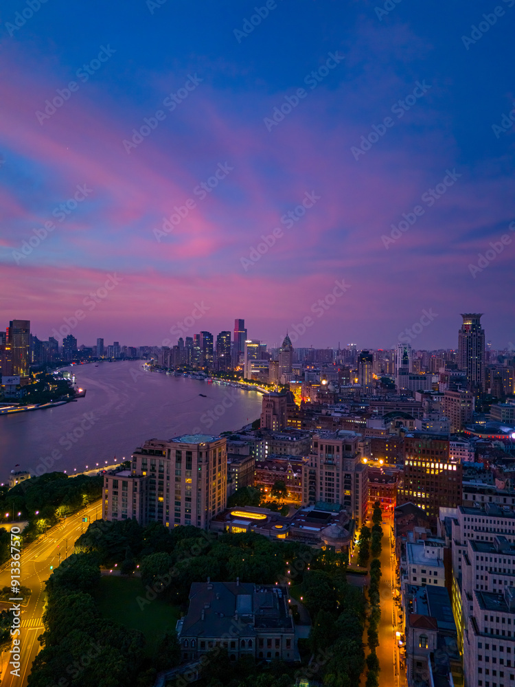Obraz premium Aerial view of modern city skyline and burning clouds at sunrise in Shanghai.