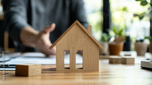 Balancing the property sector the real estate agent explains the house style and purchase agreement in a modern office with a wooden house model