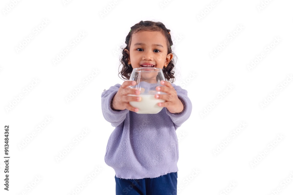 A cheerful little Asian girl holding a glass of milk, on a white background A cheerful little Asian girl holding a glass of milk, on a white background