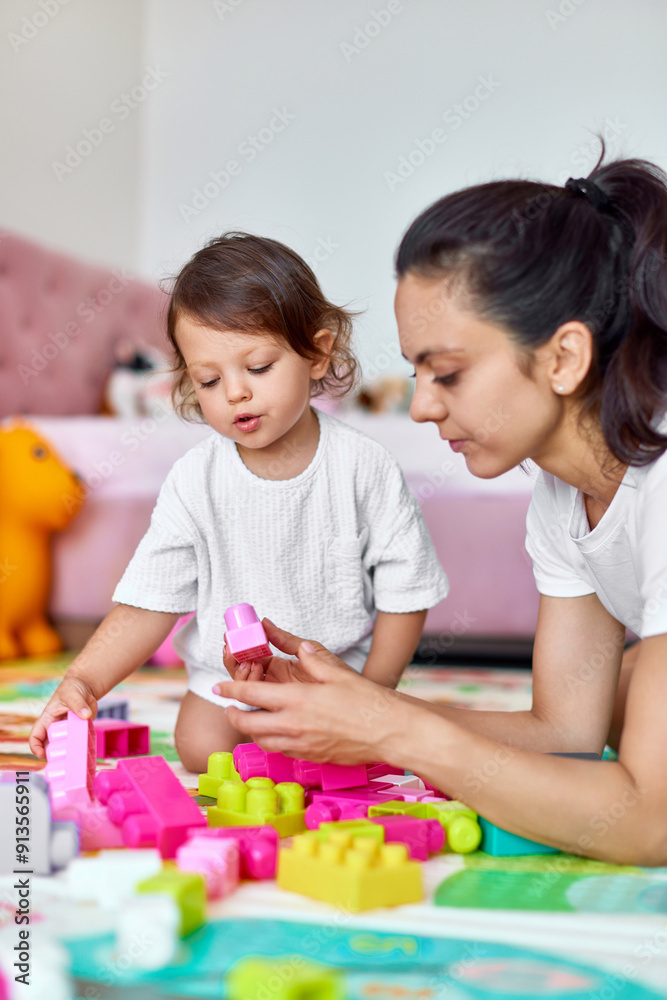 cute baby girl and her loving mother playing with colorful blocks in the children room, early development cute baby girl and her loving mother playing with colorful blocks in the children room, early development