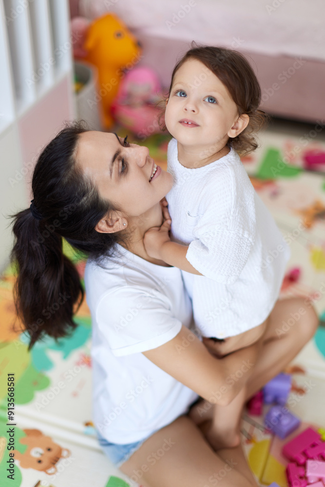 happy mother with cute baby girl in white t-shirt having fun together happy mother with cute baby girl in white t-shirt having fun together