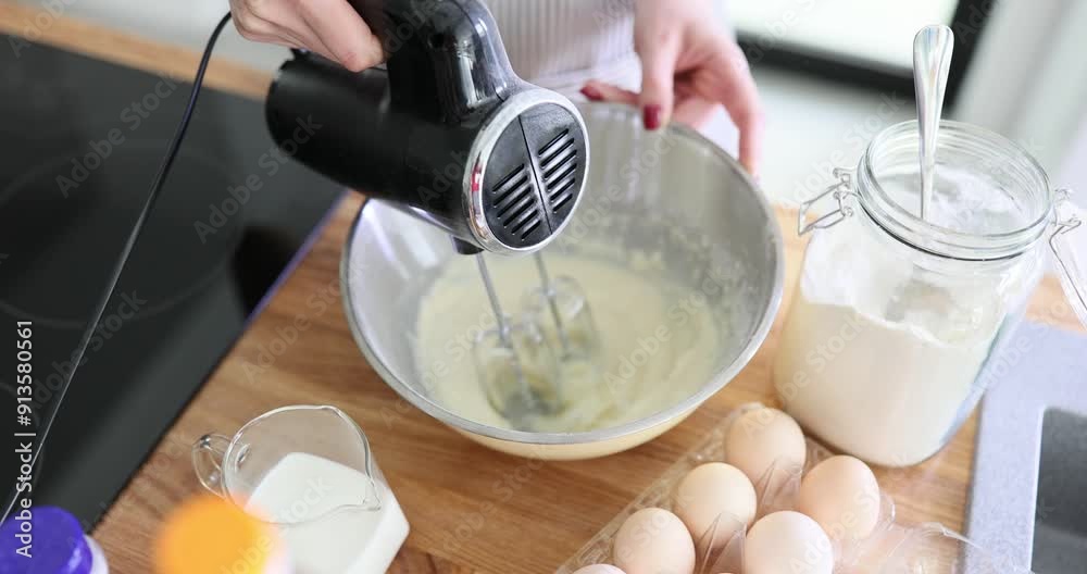 Chef mixes ingredients with electric mixer in bowl