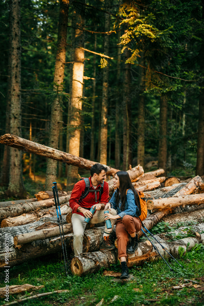 A diverse couple in nature taking a rest after hiking A diverse couple in nature taking a rest after hiking