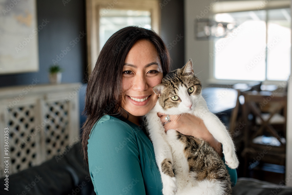 Smiling woman holding cat inside home Smiling woman holding cat inside home