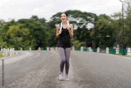 Asian girl jogging Exercise in the morning with headphones on and a happy smile.