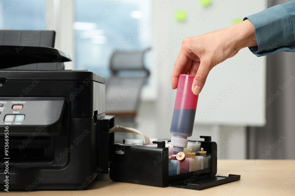 Woman refilling ink in modern printer at workplace indoors, closeup Woman refilling ink in modern printer at workplace indoors, closeup
