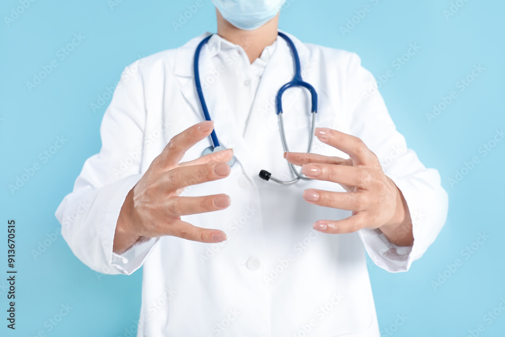 Doctor holding something on light blue background, closeup