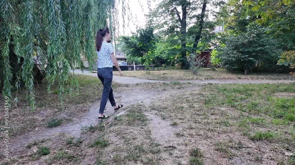 Woman walking in the city in summertime wearing jeans and t-shirt and sunglasses. Slow motion video Woman walking in the city in summertime wearing jeans and t-shirt and sunglasses. Slow motion video